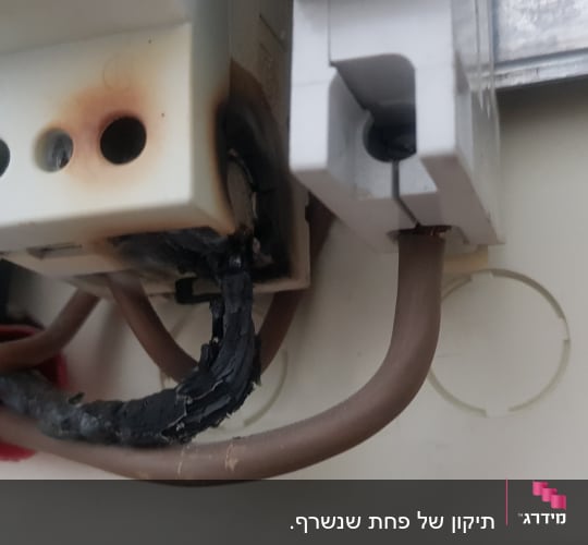 חוטים שרופים בלוח חשמל עם סימני כווייה